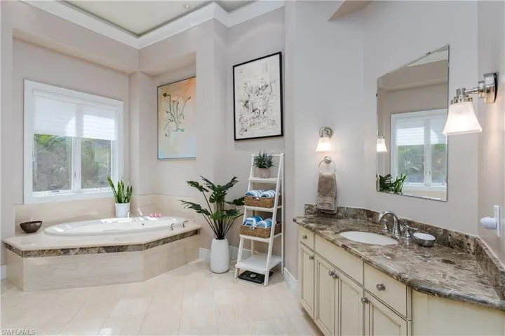Full bathroom featuring vanity, plenty of natural light, a bath, crown molding, and tile patterned floors
