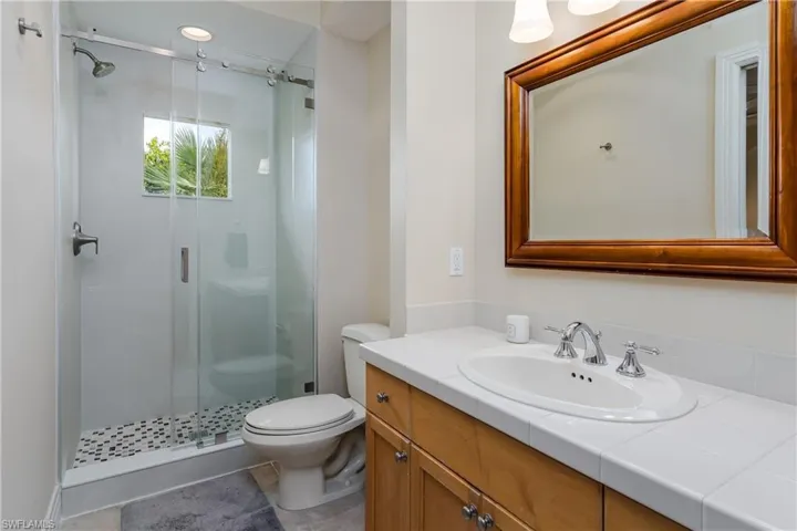 Bathroom with vanity, a stall shower, and tile patterned floors