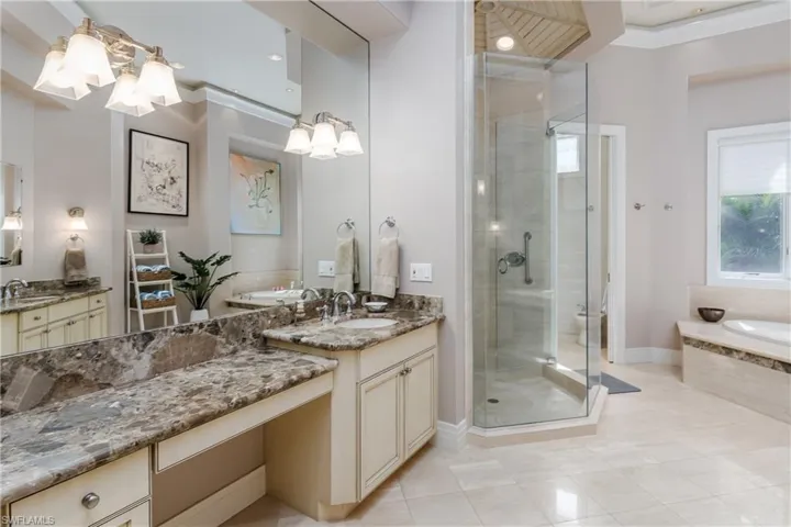 Full bathroom featuring a chandelier, a shower stall, a bath, crown molding, and vanity