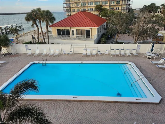 View of pool with a water view and a patio