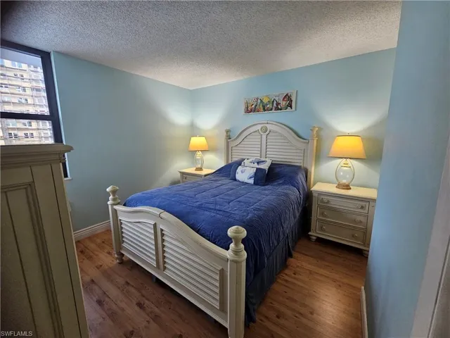 Bedroom featuring dark hardwood / wood-style floors and a textured ceiling