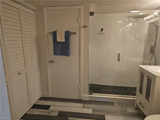 Bathroom featuring vanity, an enclosed shower, and hardwood / wood-style flooring