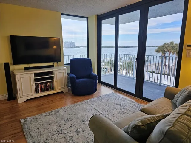 Living area featuring  NEW IMPACT WINDOWS & floor to ceiling IMPACT SLIDERS with a Big Bay View where the dolphins love to play, wood-style plank flooring.