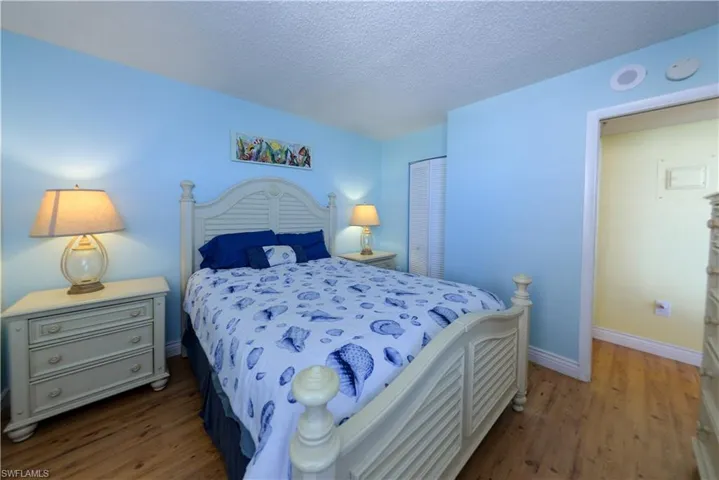 Bedroom featuring a closet, a textured ceiling, and wood-style floors