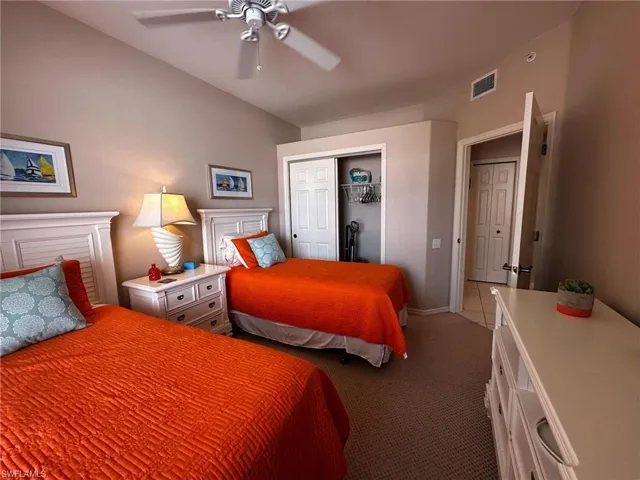 Bedroom featuring a closet, dark carpet, and a ceiling fan