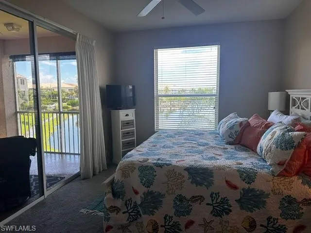 Carpeted bedroom featuring access to exterior and a ceiling fan