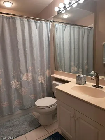 Bathroom featuring tile patterned floors, vanity, and shower / bath combo with shower curtain