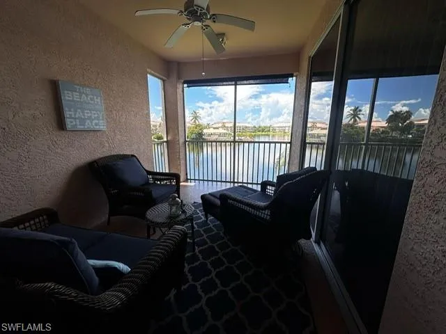 Sunroom with a textured wall and a water view