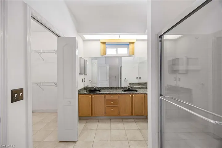Primary bath with double sinks, granite counters , walk in closet and walk in shower