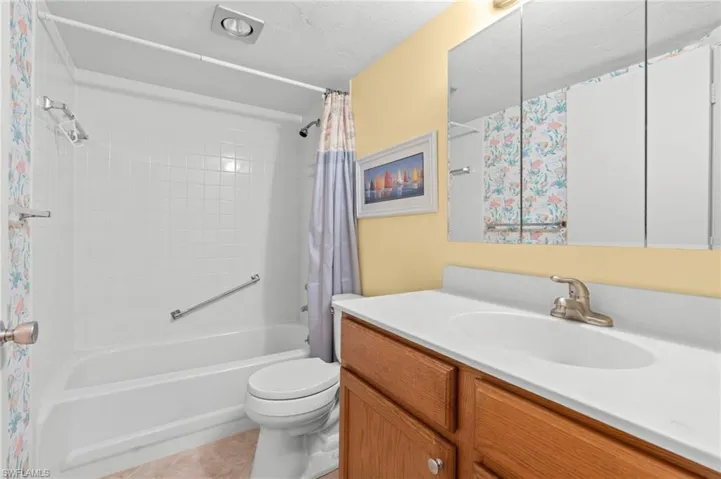 Guest Full bath featuring shower / tub combo, vanity, light tile patterned floors, and a textured ceiling