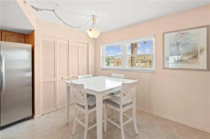 Dining area with light tile patterned floors and baseboards