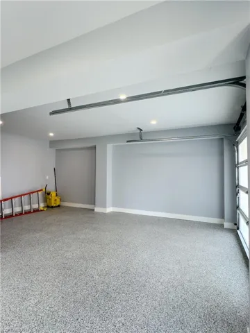 Garage featuring baseboards and recessed lighting