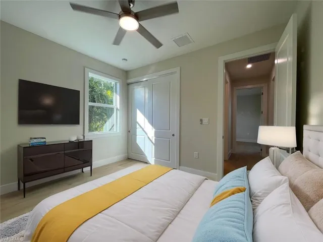 Bedroom with light wood-type flooring, a closet, and a ceiling fan