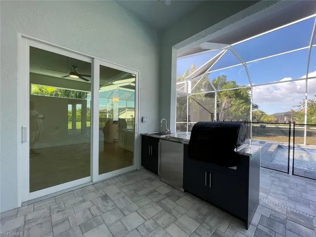 View of patio / terrace with an outdoor kitchen and a lanai