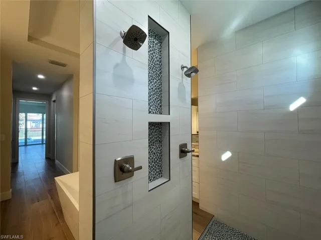 Bathroom featuring a tile shower and wood finished floors