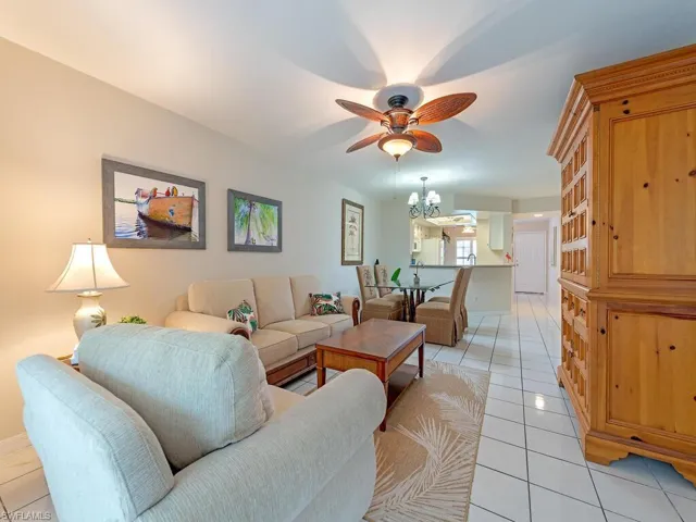 Living room featuring a ceiling fan, a chandelier, and light tile patterned floors
