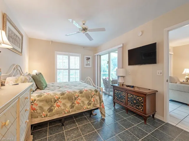 Bedroom featuring dark tile patterned floors, access to outside, and ceiling fan