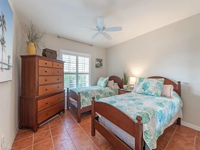 Bedroom with baseboards, light tile patterned floors, and ceiling fan