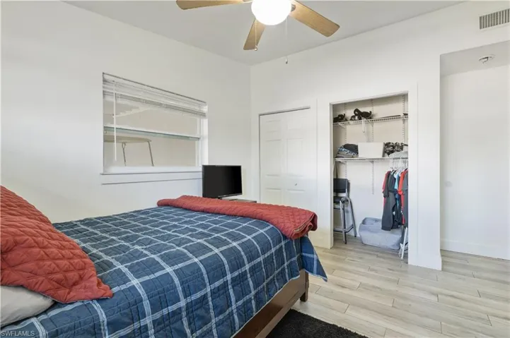 Bedroom featuring light wood-style flooring, two closets, and a ceiling fan