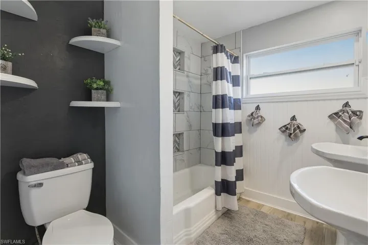 Full bathroom with light wood-type flooring and shower / bath combo