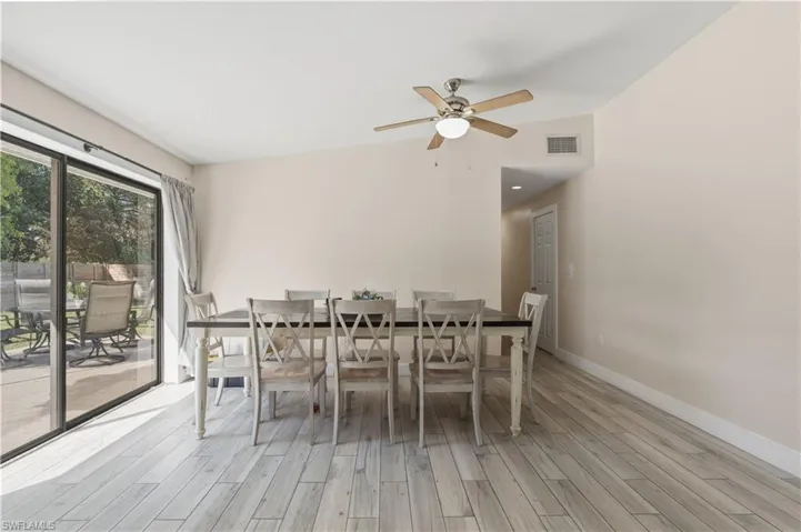 Dining space with light wood-style floors, a ceiling fan, and vaulted ceiling