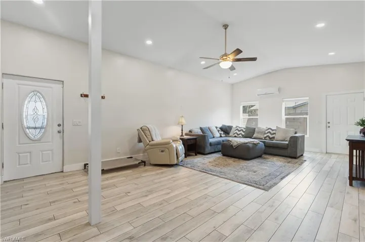 Living area featuring light wood-style floors, ceiling fan, recessed lighting, and lofted ceiling