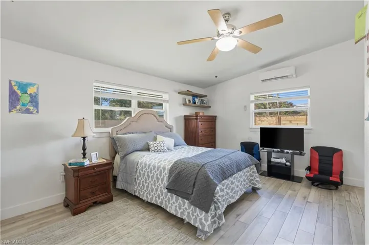 Bedroom with lofted ceiling, ceiling fan, and wood finished floors