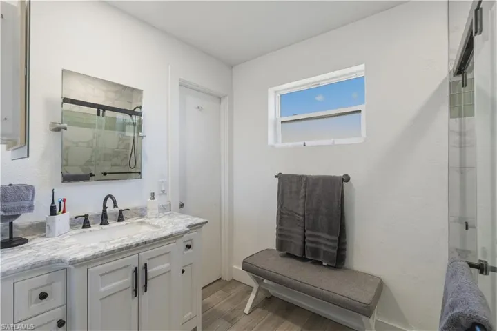 Bathroom featuring vanity, light wood-type flooring, and a stall shower