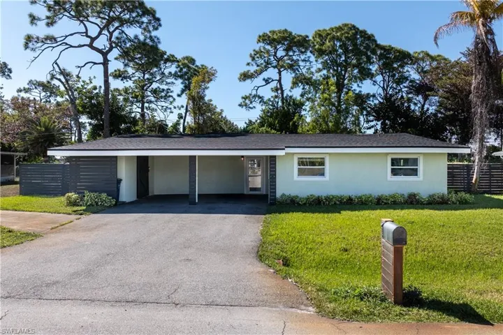 Single story home with asphalt driveway, an attached carport, and stucco siding