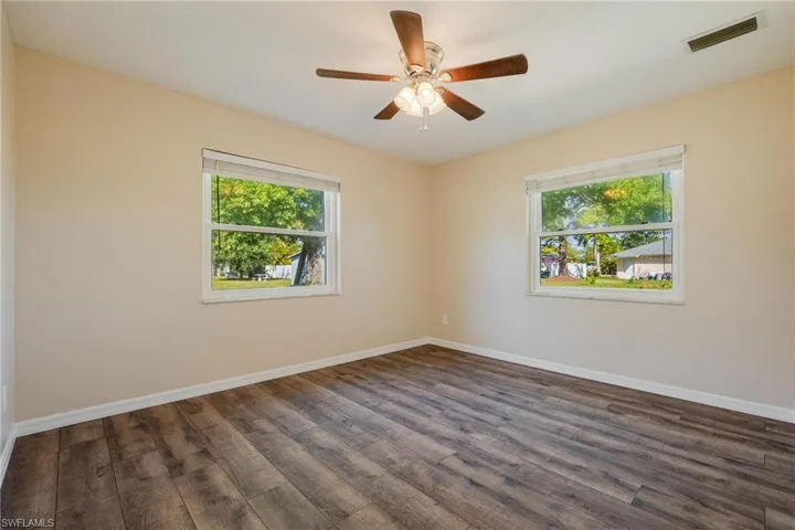 Empty room featuring dark wood finished floors and ceiling fan