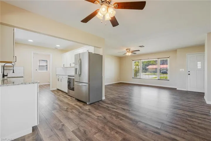 Kitchen with appliances with stainless steel finishes, light stone countertops, tasteful backsplash, white cabinetry, and recessed lighting