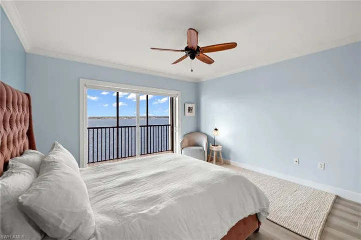 Bedroom featuring ceiling fan, a water view, crown molding, and access to outside