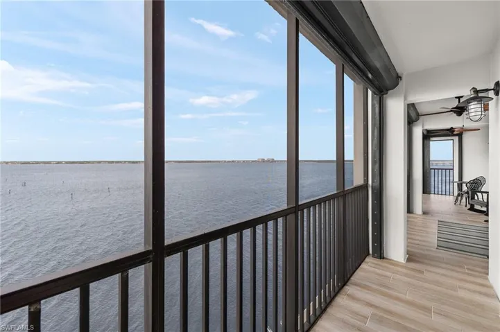 Unfurnished sunroom featuring ceiling fan and a water view