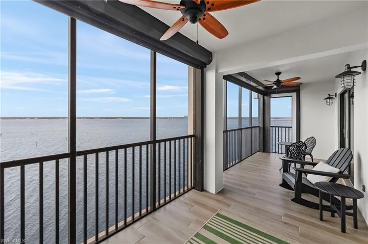 Sunroom with ceiling fan and a water view