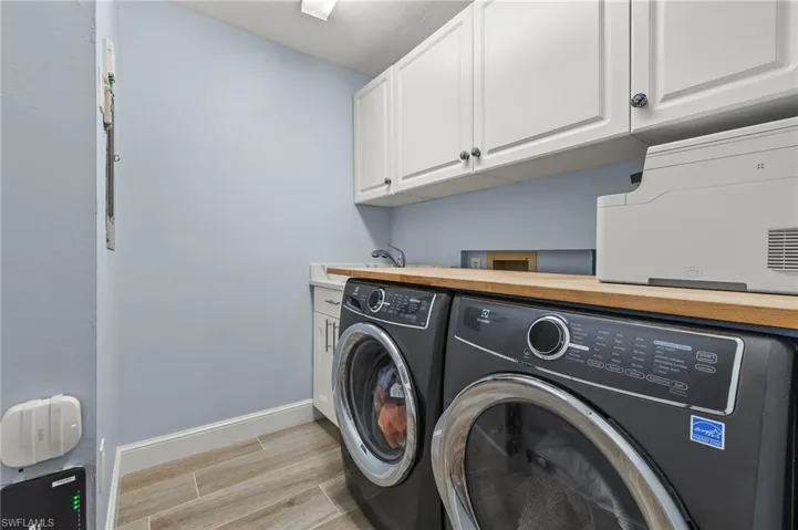 Laundry room featuring cabinets and washer and clothes dryer