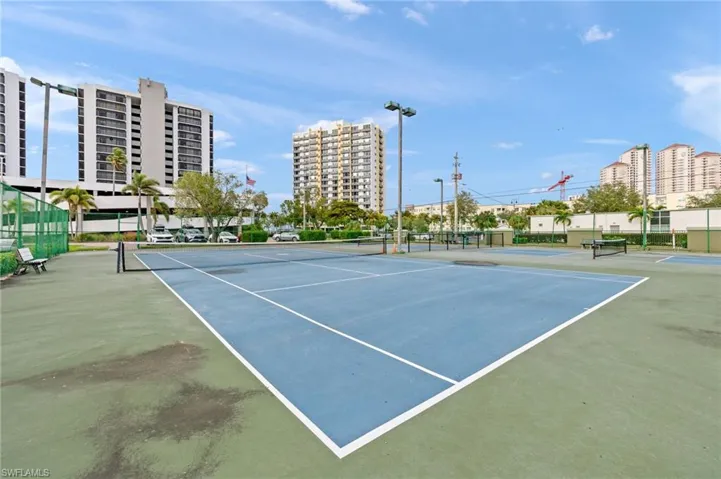 View of tennis court with basketball hoop