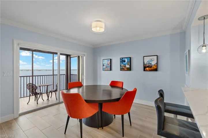 Dining area with a water view and crown molding