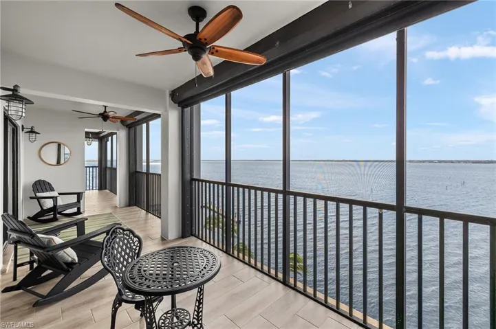 Sunroom / solarium featuring ceiling fan and a water view