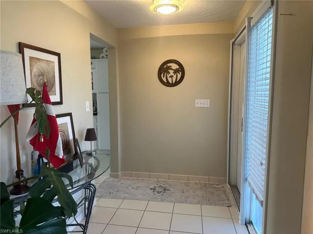 Corridor with light tile patterned flooring and baseboards