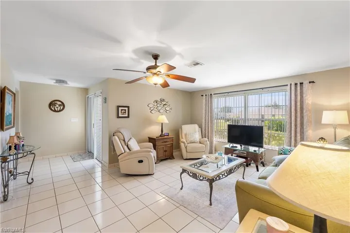 Living room featuring light tile patterned flooring and a ceiling fan