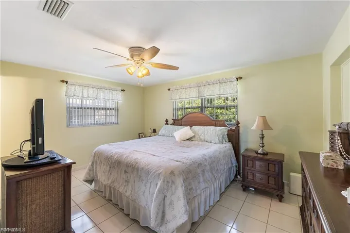 Bedroom with a ceiling fan and light tile patterned floors