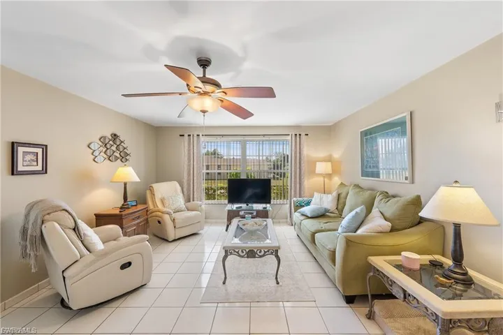 Living room featuring tile patterned floors and a ceiling fan