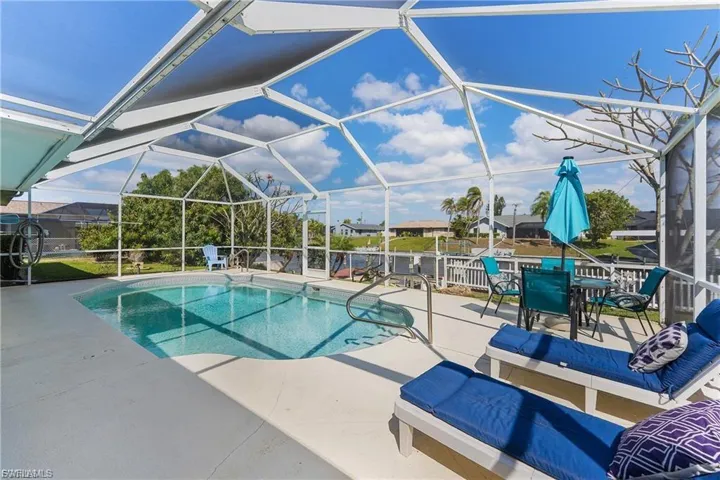 Swimming pool with glass enclosure, a sunroom, and a patio area