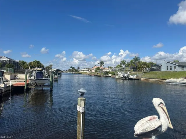 Dock with a water view, boat lift, and a residential view
