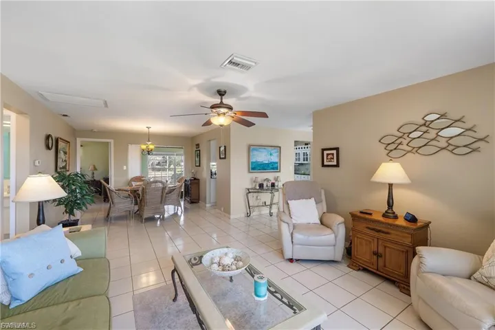 Living area featuring a ceiling fan and light tile patterned floors