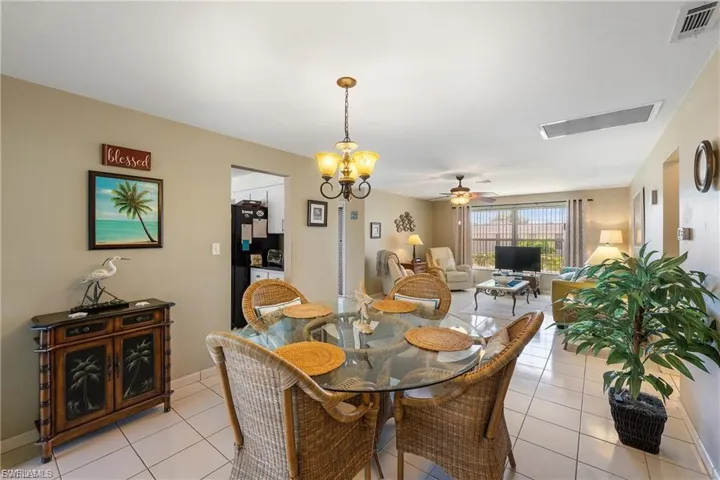 Dining space with a ceiling fan, suspended lighting, and light tile patterned floors
