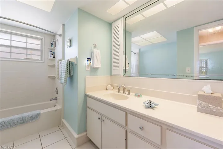 Bathroom with vanity, shower / washtub combination, and light tile patterned flooring