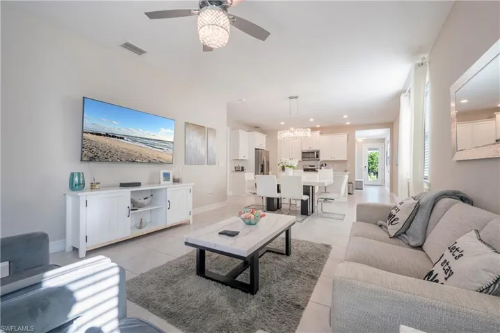 Living area featuring ceiling fan, light tile patterned floors, and suspended lighting