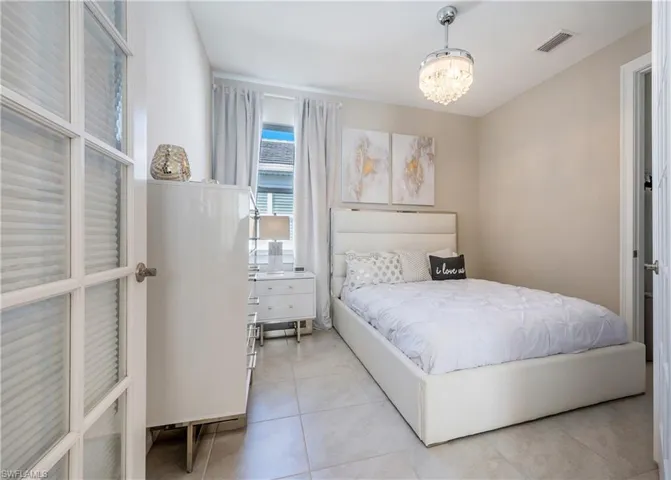 Bedroom featuring suspended lighting and light tile patterned flooring