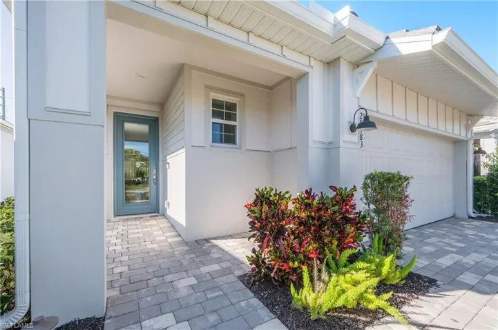 Property entrance featuring an attached garage and driveway